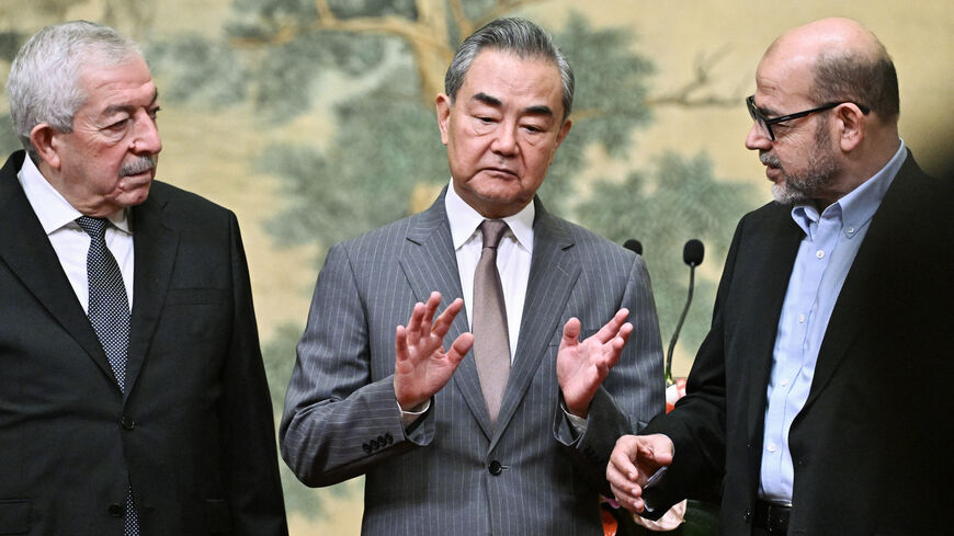 TOPSHOT - (L-R) Mahmoud al-Aloul, Vice Chairman of the Central Committee of Palestinian organisation and political party Fatah, China's Foreign Minister Wang Yi, and Mussa Abu Marzuk, senior member of the Palestinian Islamist movement Hamas, attend an event at the Diaoyutai State Guesthouse in Beijing on July 23, 2024. China's Foreign Minister Wang Yi on July 23 hailed an agreement by 14 Palestinian factions to set up an "interim national reconciliation government" to govern Gaza after the war. (Photo by Pe